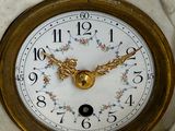 a white marble clock with gold hands and a gold clock face