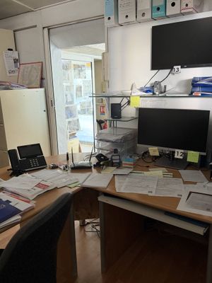 un bureau sur lequel sont posés deux écrans et un ordinateur portable