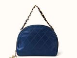a blue purse with a chain hanging from it ' s handle