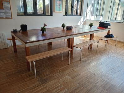 une table et un banc en bois au milieu d'une pièce