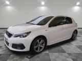 la voiture blanche est garée sur un sol en damier dans le garage