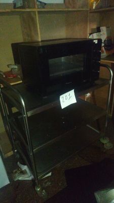 a microwave sitting on a cart in a kitchen