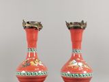 une paire de vases rouges ornés de motifs verts et dorés