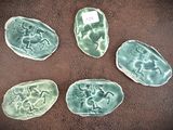 quatre pièces de poterie verte posées sur une surface marron