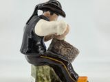 a figurine of a man sitting on a rock