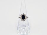 gros plan d'une bague avec une pierre noire entourée de diamants blancs