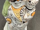 a ceramic figurine of a man holding a baby