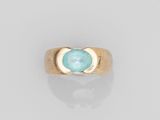 une bague en or avec une pierre bleue au centre