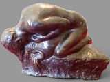 a sculpture of a man laying on top of a rock