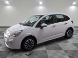 la petite voiture blanche est garée sur un sol en damier