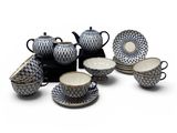 a group of black and white dishes and cups on a white surface