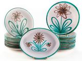 une pile d'assiettes ornées de fleurs, posées sur une surface blanche