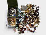 a box full of assorted jewelry on a white surface