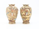 pair of asian vases on a white surface with a white background