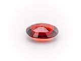 a close up of a red diamond on a white surface