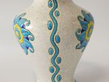 a white vase with blue and yellow designs on it