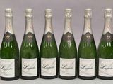 six bouteilles de champagne sont alignées sur une table