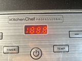 a digital clock on the side of a kitchen stove