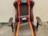 a black and orange gaming chair with a logo on it
