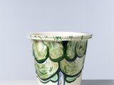 une tasse blanche ornée d'un motif vert et bleu