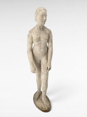 une photo représentant la statue d'un garçon debout sur un socle en bois