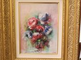 a picture of a painting of flowers in a vase on a easel