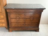 une commode en bois avec un plateau en marbre dans une chambre