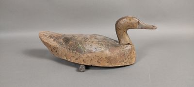 an old wooden duck sitting on top of a gray surface