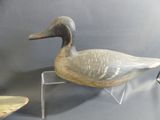a duck that is sitting on a stand next to another duck
