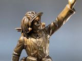 bronze statue of a man with a gun on a table