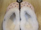 pair of pink slippers with donuts on them sitting on a wooden floor