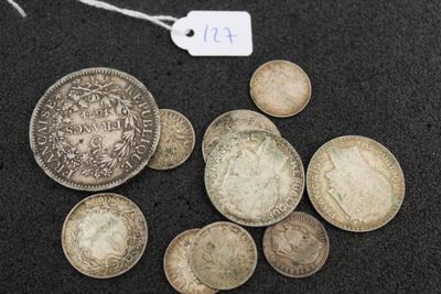 some silver coins are sitting on a black surface with a price tag