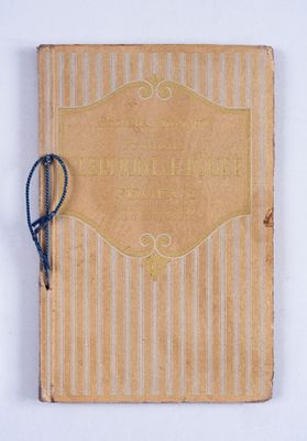 an old book with a blue string tied to it on a white surface