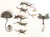 de nombreux petits lézards et libellules en métal sur une surface blanche