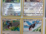 Plusieurs cartes Pokémon sont accrochées au mur d'une pièce.