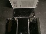 three black iphones are sitting on a table with a box in front of them