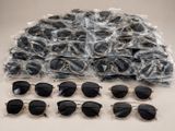 several pairs of sunglasses are wrapped in plastic bags on a table