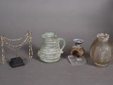 three vases, a necklace, and other items displayed on a table