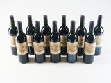 several bottles of wine are lined up in a row on a white surface