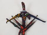 a sculpture made out of sticks with a face on top of it