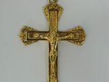 a close up of a gold cross on a white surface