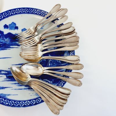 a blue and white plate with silver spoons and spoons on it