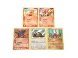 quatre cartes Pokémon sont empilées les unes sur les autres