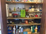 a pantry with a lot of clutter on the shelves