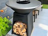 a fire pit sitting on a patio with a lot of wood