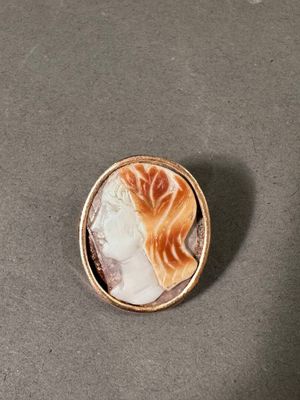 un gros plan sur une broche représentant le visage d'une femme