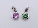 une paire de boucles d'oreilles en pierre violette et verte posées sur une surface blanche