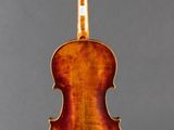 an old violin on a stand against a gray background