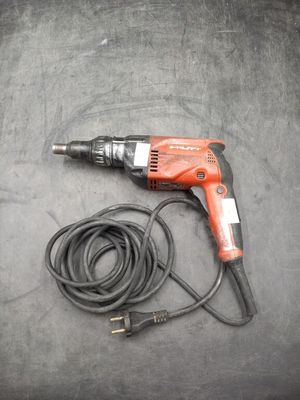 une perceuse électrique et un cordon d'alimentation par terre