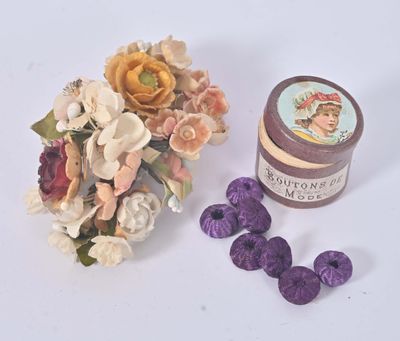 a small jar of cream next to a bouquet of flowers